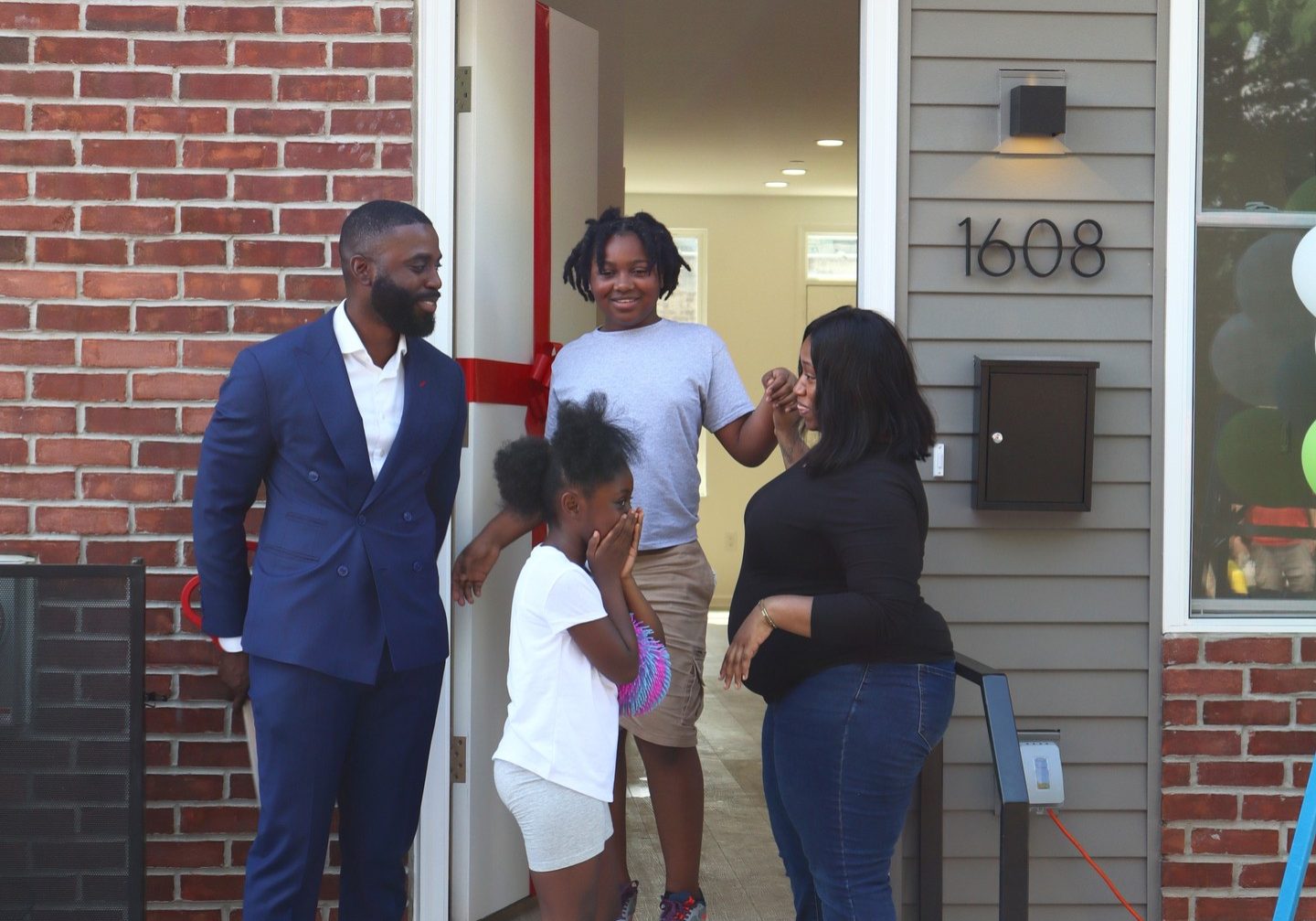 Family standing outside newly purchased home.